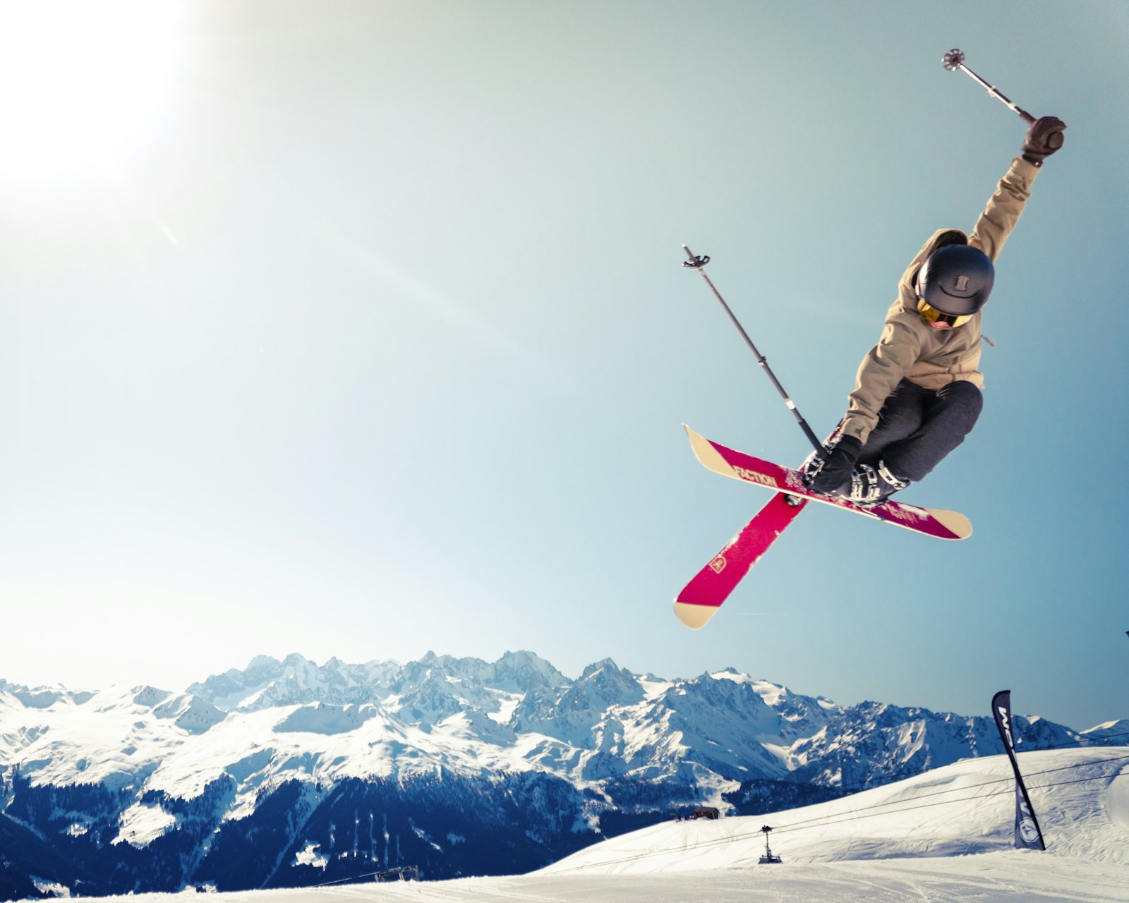 Skier in mid-air above a snowy mountain slope