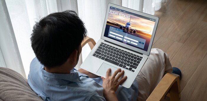 Traveller booking a flight on a laptop