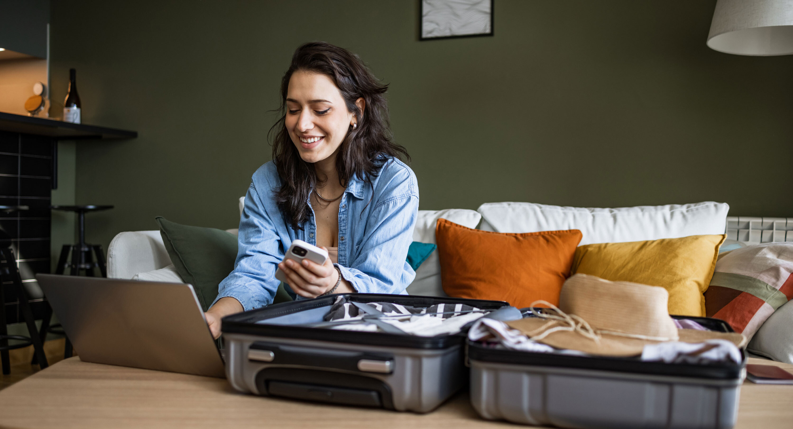 Traveller planning a trip on phone and laptop